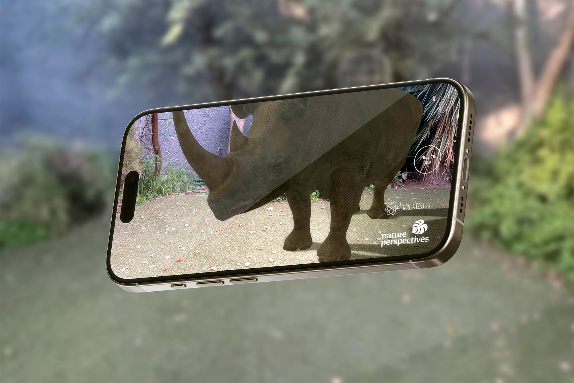Smartphone displaying an augmented reality image of a rhinoceros standing on a paved surface with plants in the background.